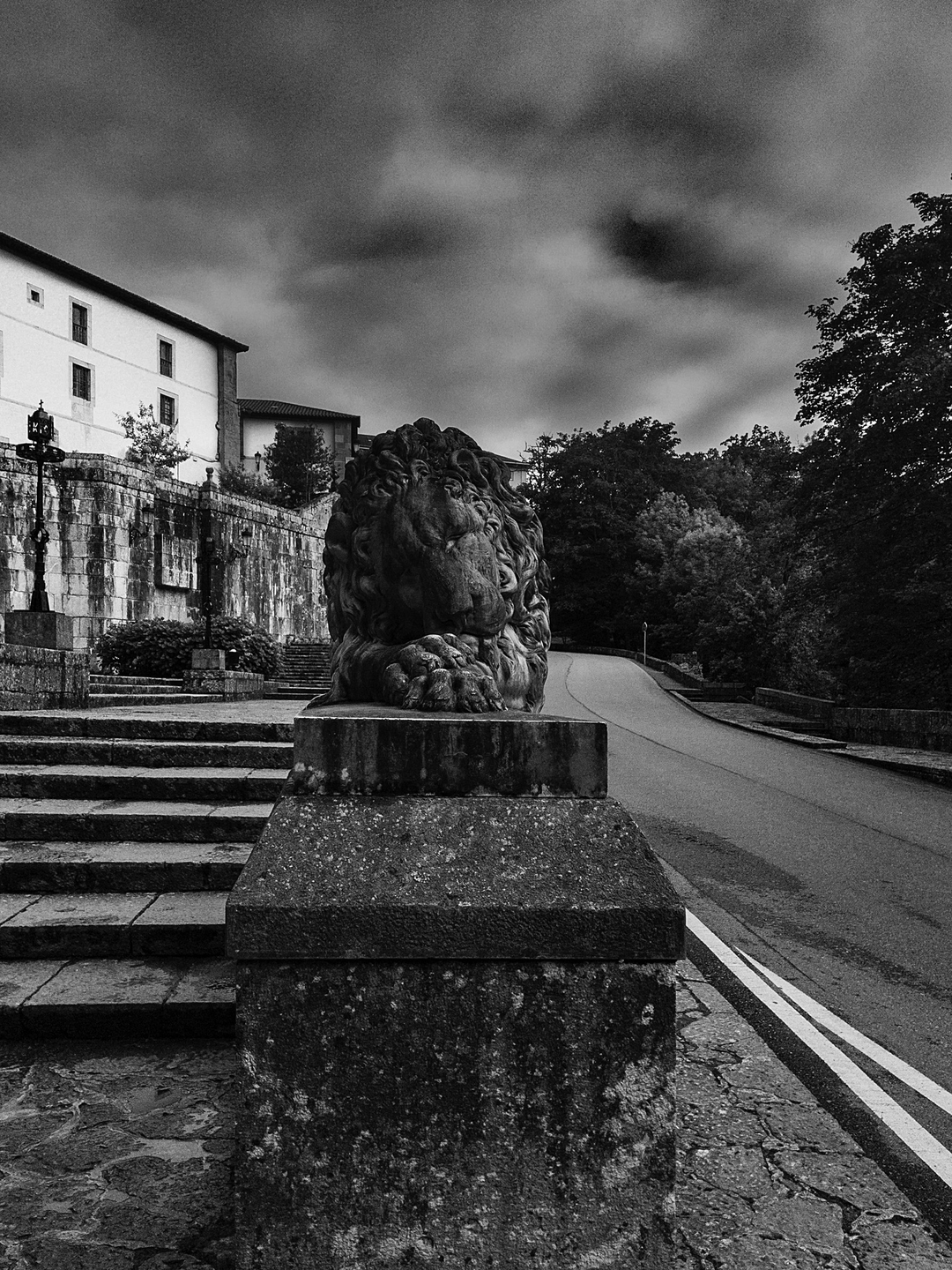  Majestic Lion Statue at the Entrance of Covadonga Cave, Asturias, Spain, Depicting Strength and Heritage Against a Dramatic Sky, Captured in Black and White for a Timeless and Historic Feel. (c) pmartinasi