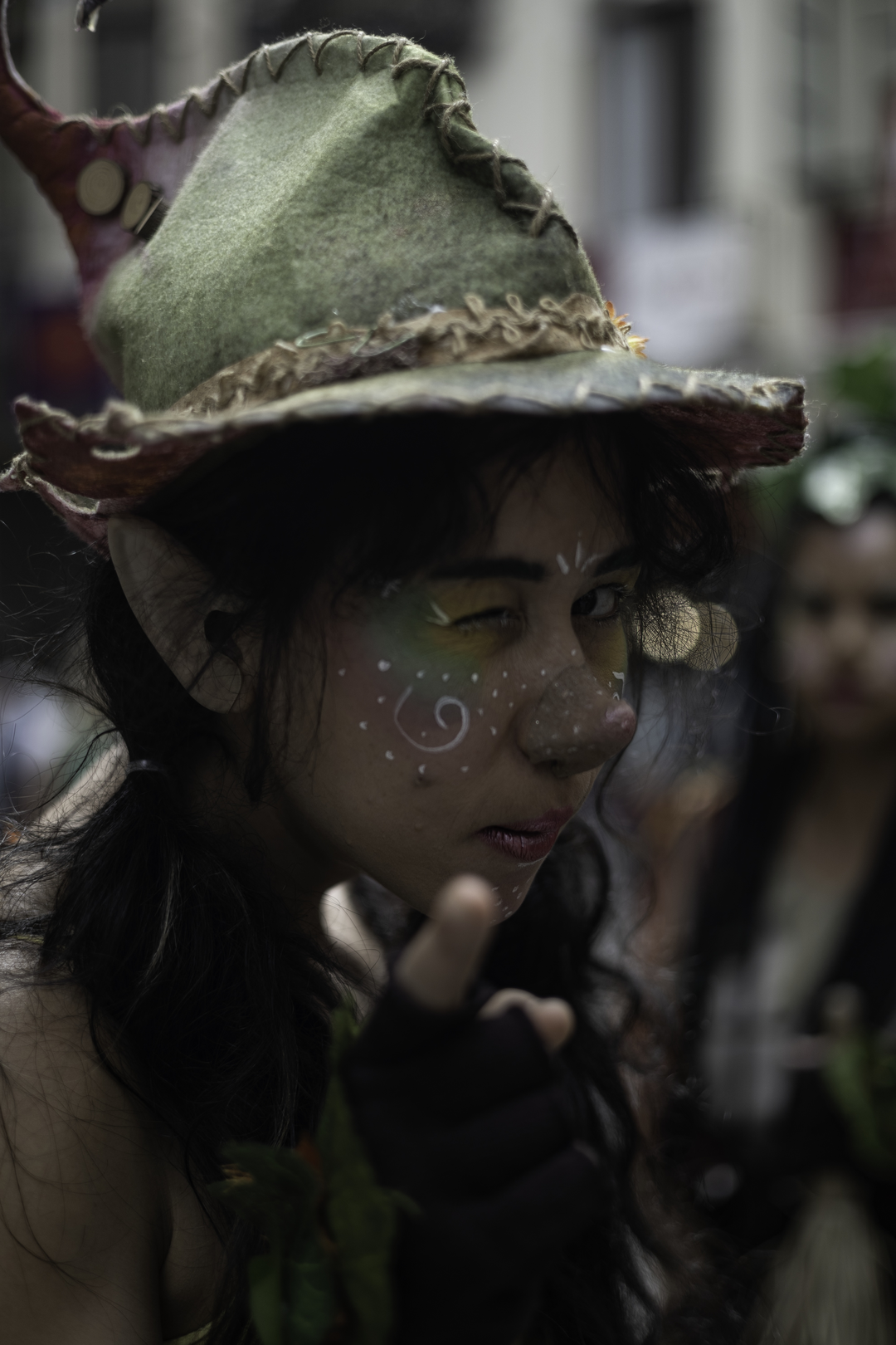  A whimsical forest elf character captured at the Medieval Fair and Market of Ávila, Spain. The cosplayer wears a nature-inspired costume with a wide-brimmed hat, pointed ears, and elaborate face paint, evoking a magical woodland spirit. Medieval Market and Fair in Ávila. September 2025. (c) pmartinasi