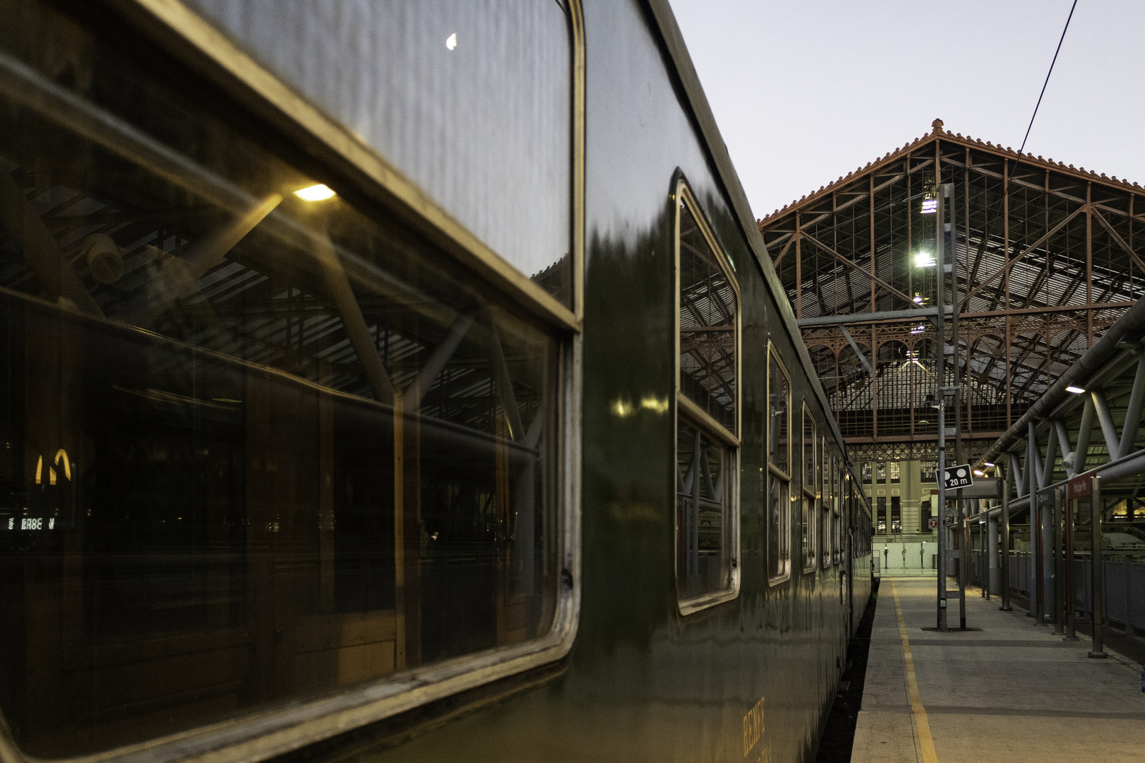  The historic Felipe II train stopped at Madrid's Príncipe Pío station. The green vintage carriage reflects the station's ironwork and soft twilight ambiance, showcasing timeless railway heritage. (c) pmartinasi