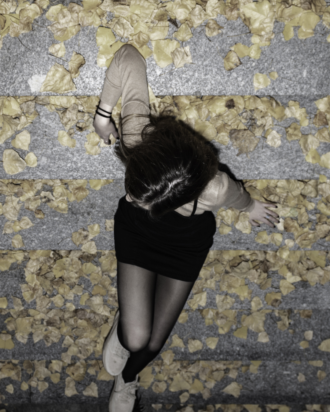 Top View of a Girl Lying on Leaf-Covered Steps in Autumn. (c) pmartinasi