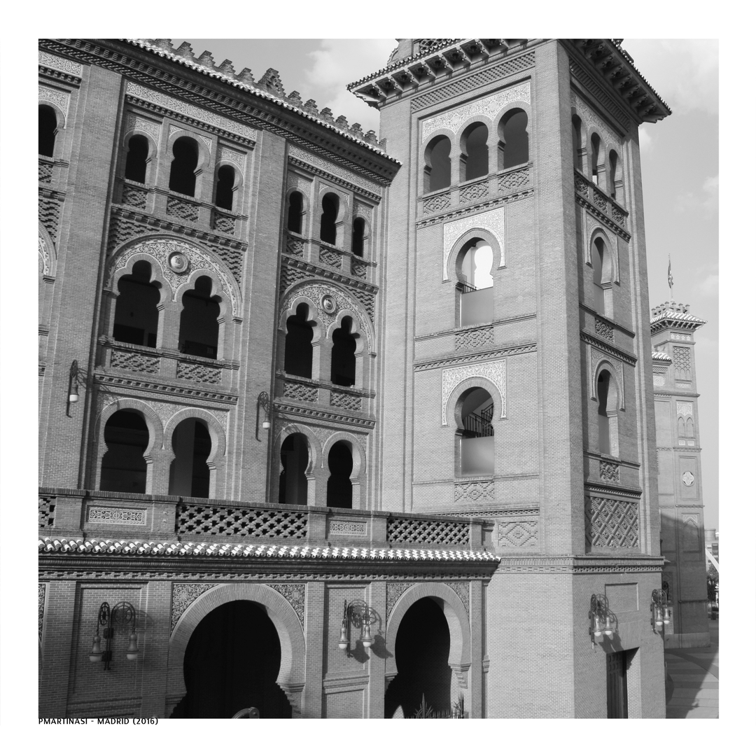  Striking black and white photograph of Las Ventas, Madrid's iconic bullfighting arena, highlighting the intricate Neo-Mudéjar design and elaborate brickwork details under soft daylight. (c) pmartinasi