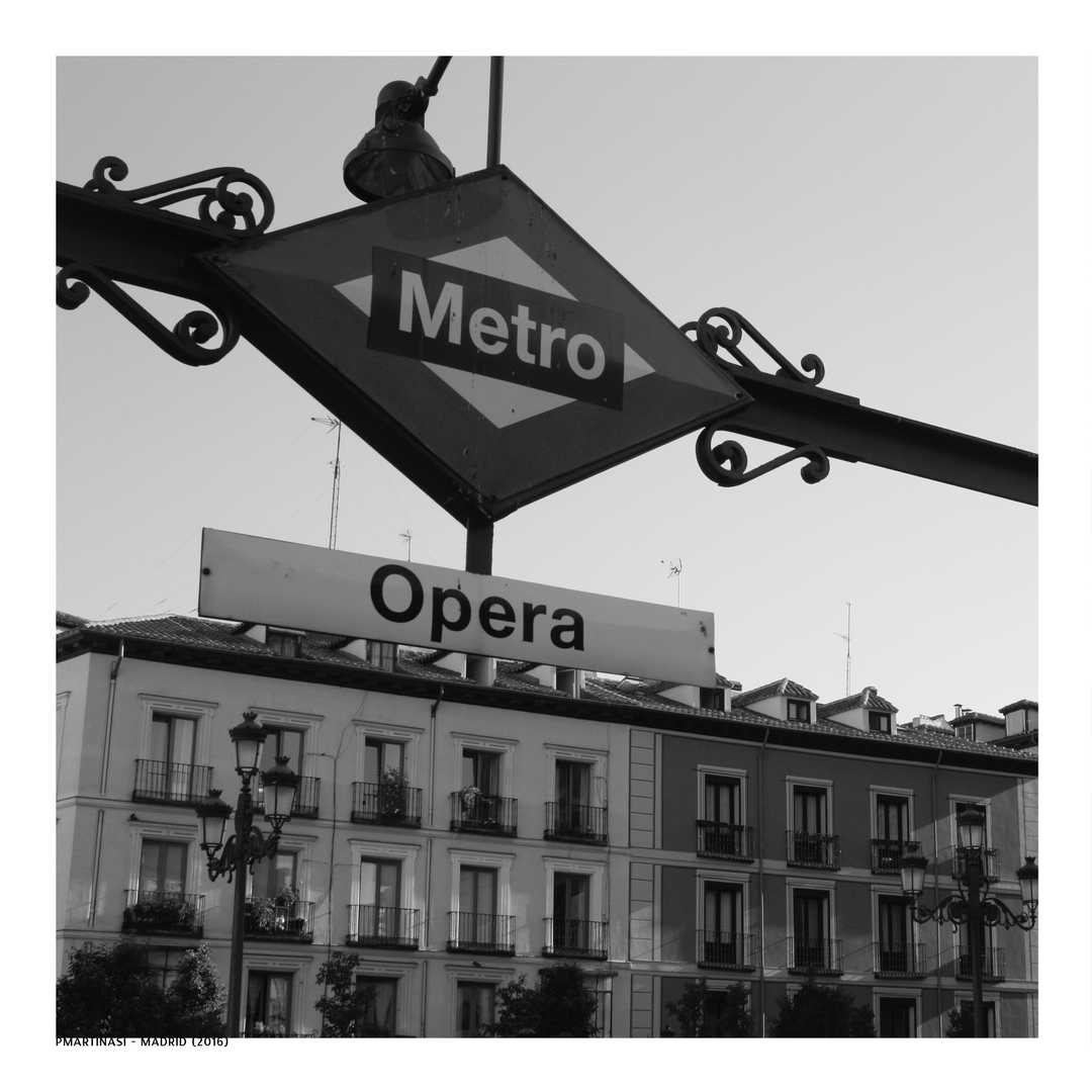  Madrid's Opera Metro station sign at street level, framed by grand classical buildings and evocative European ambience. (c) pmartinasi