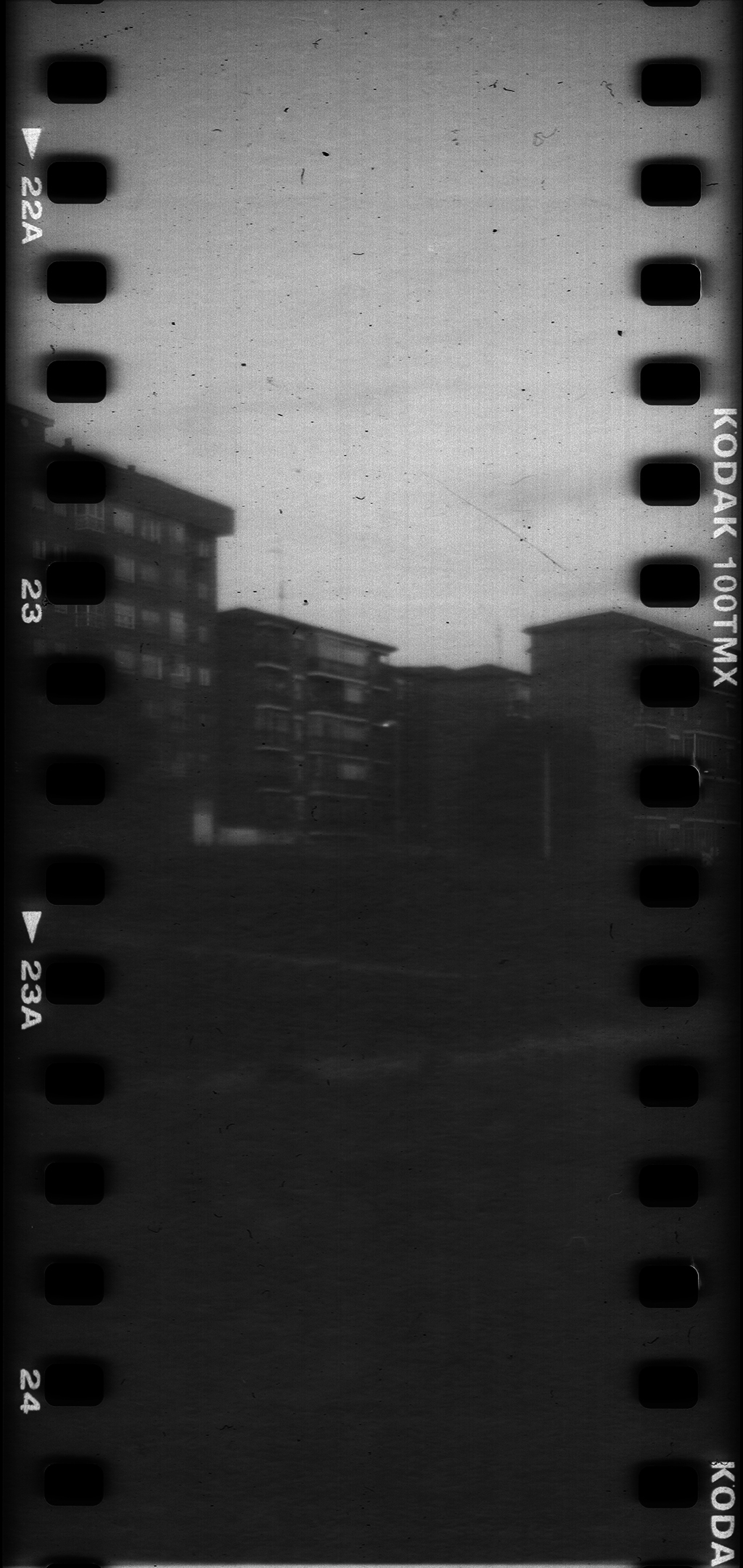  Analog black and white street photography of an urban scene in Avila, captured on Kodak 100TMX film reel. Featuring street lamps and buildings, this vintage film aesthetic evokes nostalgia and timeless urban imagery (c) pmartinasi