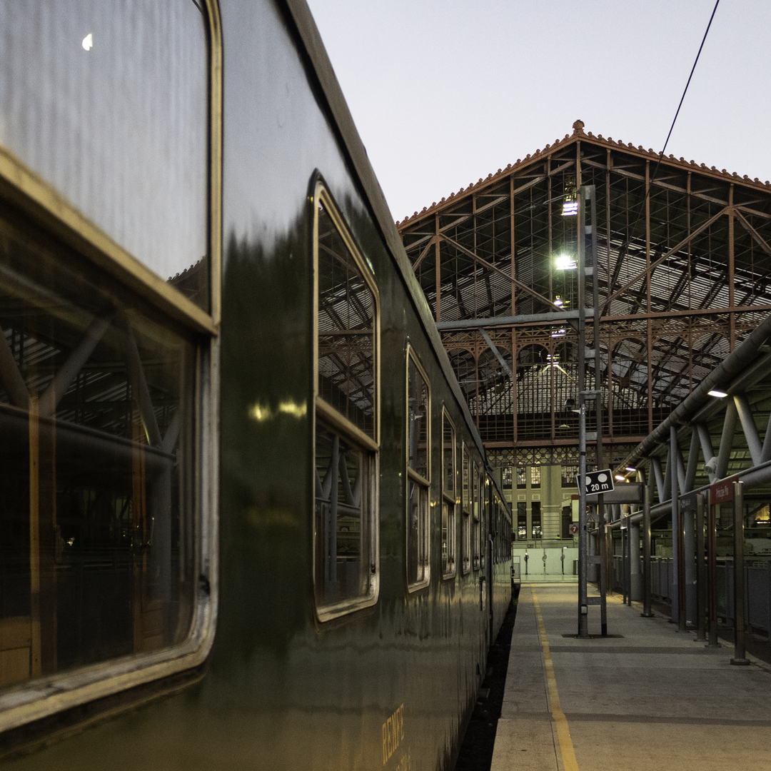  The historic Felipe II train stopped at Madrid's Príncipe Pío station. The green vintage carriage reflects the station's ironwork and soft twilight ambiance, showcasing timeless railway heritage. (c) pmartinasi