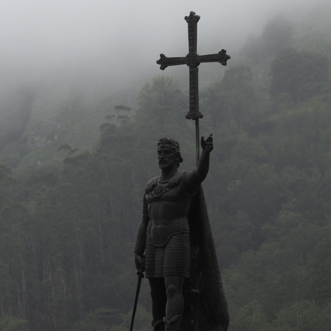  Statue of Don Pelayo, first King of Asturias, standing proudly with a cross in Covadonga, surrounded by misty mountains, evoking historical and cultural significance in Spain. (c) pmartinasi