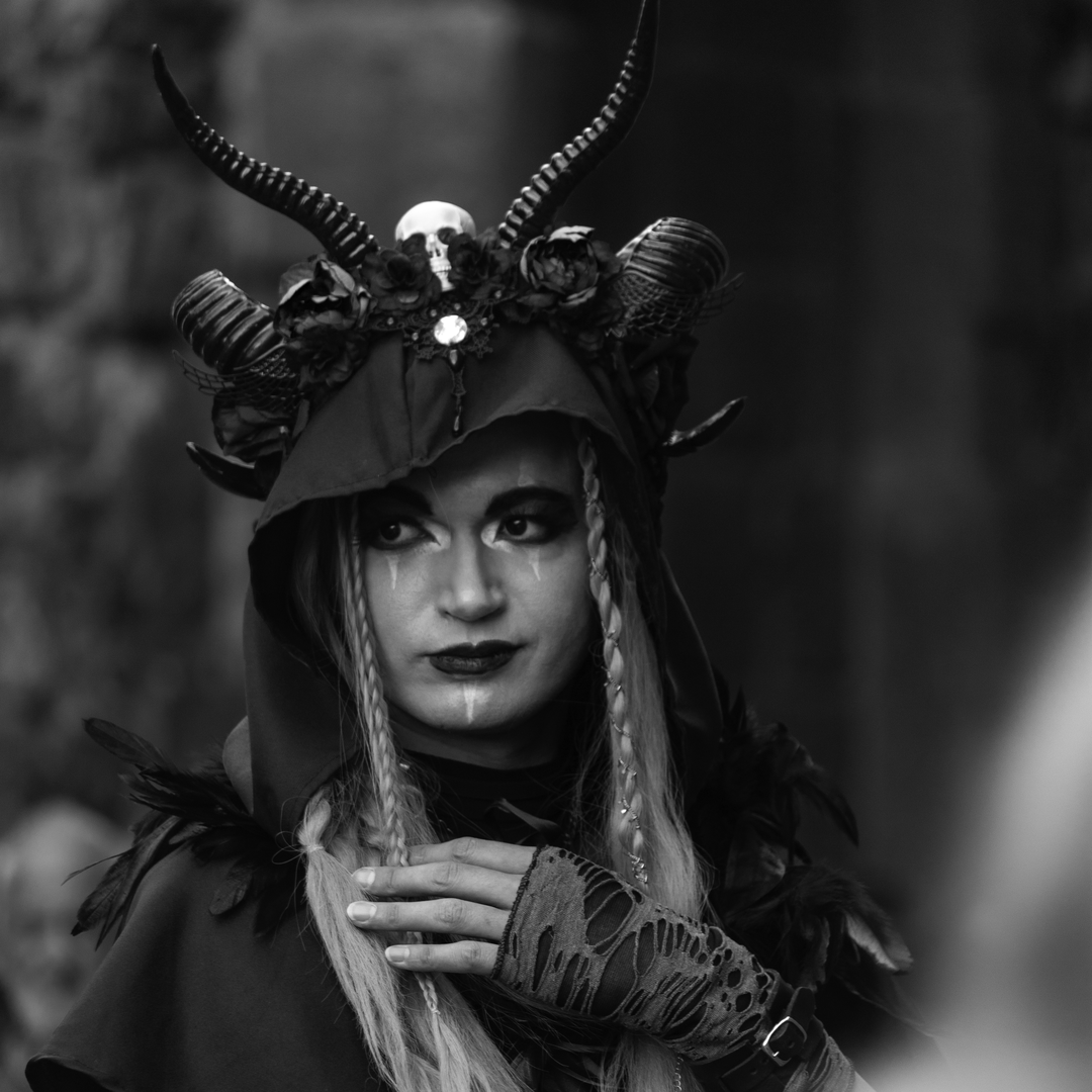  A shadow rises from the ancient stone—horned, veiled in feathers, crowned with roses and bone. This is no mere mortal, but a myth reborn at the Medieval Fair of Ávila. A vision of gothic power and forgotten magic, captured in monochrome majesty. Medieval Market and Fair in Ávila. September 2025. (c) pmartinasi