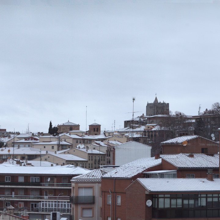  Panoramic winter view of Ávila from the south west, showing snow-covered rooftops, historic church towers and residential buildings, capturing the calm atmosphere of a cold day in a traditional Spanish city. January 2026. (c) pmartinasi