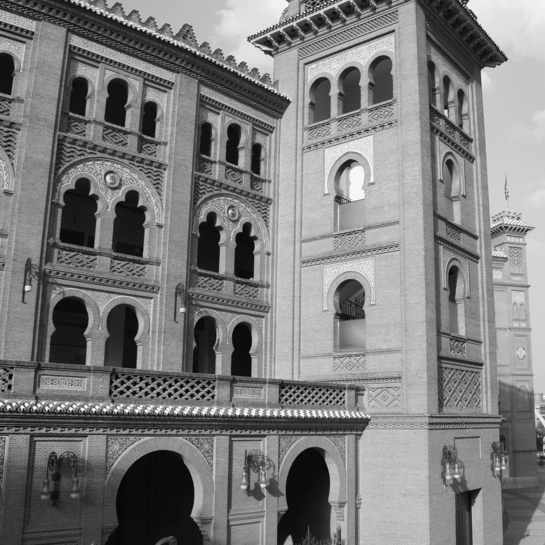  Striking black and white photograph of Las Ventas, Madrid's iconic bullfighting arena, highlighting the intricate Neo-Mudéjar design and elaborate brickwork details under soft daylight. (c) pmartinasi