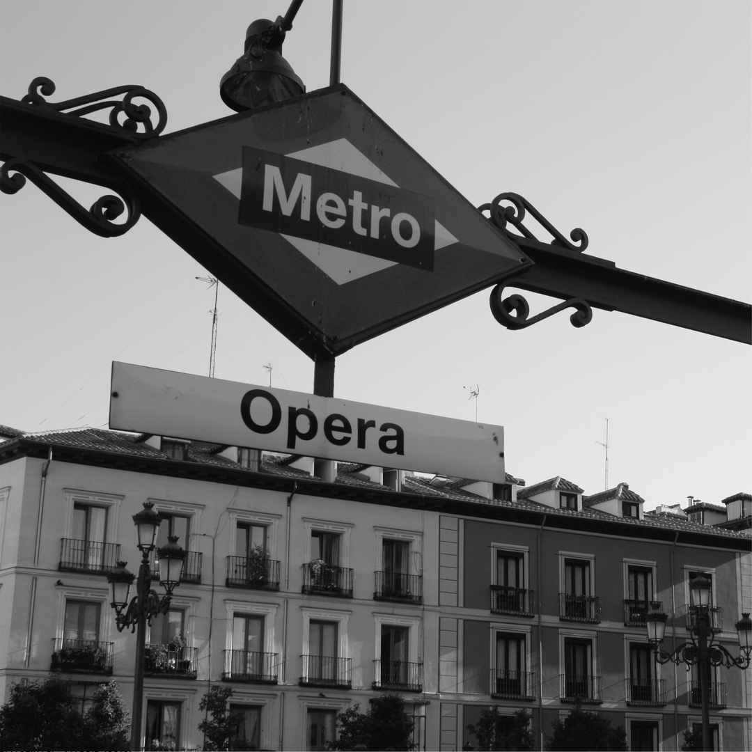  Madrid's Opera Metro station sign at street level, framed by grand classical buildings and evocative European ambience. (c) pmartinasi