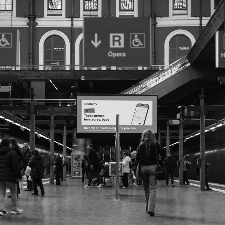 Candid black and white photograph captures a woman in motion blur walking across the platform at the busy Principe Pio Metro Station in Madrid, Spain, Europe. (c) pmartinasi